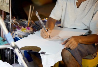 Bir adam çizim ve çizim için fırçayla çalışıyor.