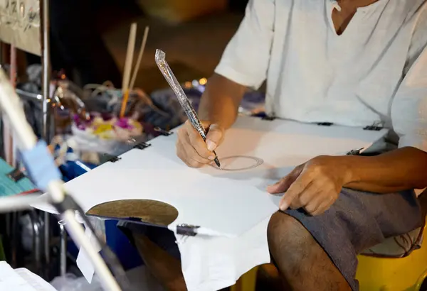 Bir adam çizim ve çizim için fırçayla çalışıyor.