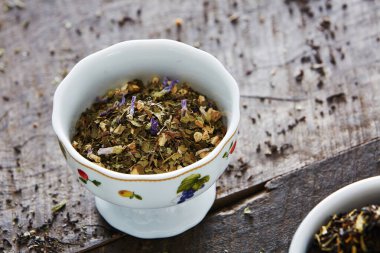 Kuru bitkisel çay, yeşil yapraklar ve bitkilerle.