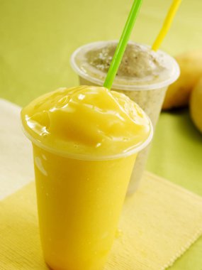 Plastik bardak, mango suyu ve saman.