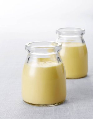 Gri mermer masada iki bardak lezzetli taze puding, yakın plan.