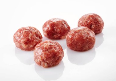 Taze çiğ et köfteleri, baharatlar ve tabakta bitkiler.