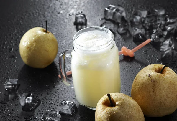 glass of fresh pear juice on dark background