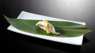 Siyah tabakta suşi rulosunu kapat.