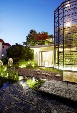 Modern bir ev, cam ve çeşmeli.