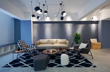 Koyu kanepesi, ahşap zemini, kahve masası ve kahve sehpası olan bir çatı katı.