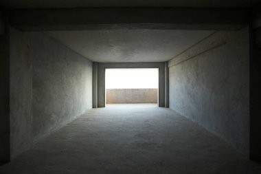 Arkaplan olarak beton duvarları, mimarisi ve bilgisayar ekranı olan boş beton oda.