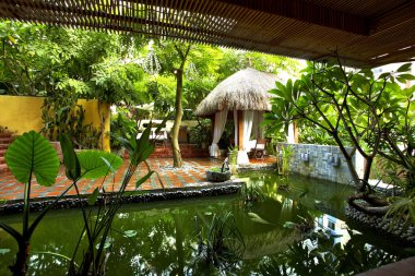 Yüzme havuzu ve palmiye ağaçları olan güzel bir tropikal tatil yeri.