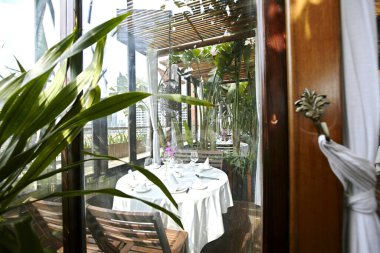 Masası ve bir bardak şarabı olan bir restoranın içinde.