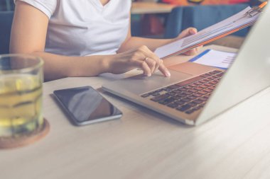 Finans raporlarını okuyan ve dizüstü bilgisayar kullanan bir iş kadını. Yüksek kalite fotoğraf