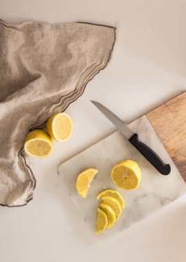 Yukarıdan görülen limonları kes. Yan tarafında bir bez ve bıçakla tahta doğrama..