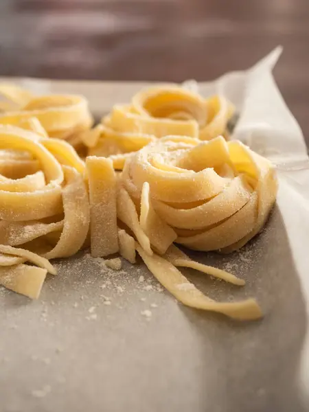 Kabartma kağıdıyla tepside birkaç demet makarna. Açı görünümünü kapat.