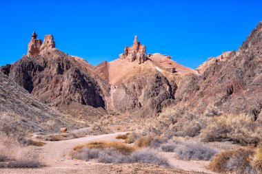 Kazakistan çölündeki dev Charyn Kanyonu. Bahar, çöl, kanyon. Şatoya benzeyen iki büyük taş mavi gökyüzünün altındaki bir dağda yatıyor..