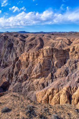 Su ve rüzgarla oyulmuş kumlu yardım kanyonları, bulutlu ve zengin çöl bitkileriyle kaplı mavi gökyüzü ve Mars manzarasını andırıyor.