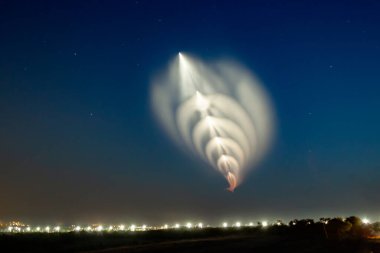 Soyuz roketi şehrin üzerinde. Güzel bir efekt için birbiri ardına birden fazla fotoğrafı istiflemek. Denizanası, güneş batarken yanmaktan gaz tüketir.