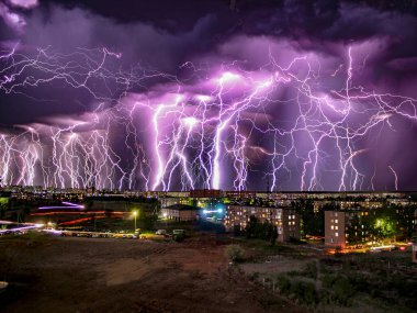 Apocalypse. Koyu bulutlu bir şehir üzerindeki fırtına sırasında bir çok yıldırım karesinin birleşimi