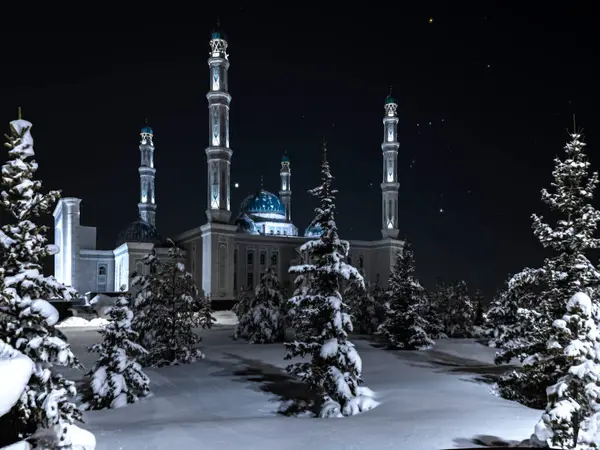 Karaganda, Kazakistan 'daki Kış Müslüman Anet Baba Camii gece karanlığında Orion takımyıldızına karşı. Ön planda kar yağdıktan sonra karda büyük köknar ağaçları ve çam ağaçları vardır..