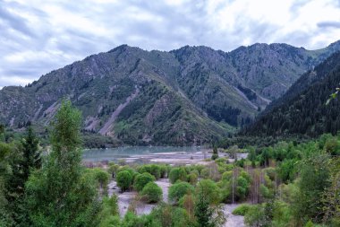 Issyk Gölü, Almaty, Kazakistan. Güzel mavi göl Issyk Büyük dağlar ve yoğun bulutlar bulutlu havada