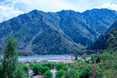 Issyk Gölü, Almaty, Kazakistan. Dağların ve kayaların arasında bir dağ gölünün su aynası. Etrafında uzun ladin ağaçları