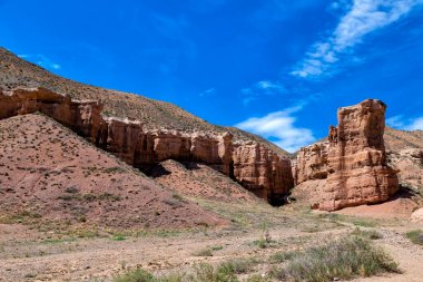Büyük Charyn Kanyonu, Almaty, Kazakistan. Kaleler Vadisi. Mavi gökyüzünün altında beyaz sirrus bulutlarıyla derin kanyon