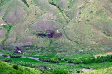 Kazakistan 'da, nehir kıyısındaki yeşil dağ geçidinde yalnız bir Kazak göçebe yurdu.
