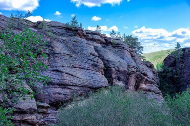 Karkaralinsk, Kazakistan. Ormandaki granit kayalar bulutlu mavi gökyüzüne karşı. Ormanda güneşli bir gün