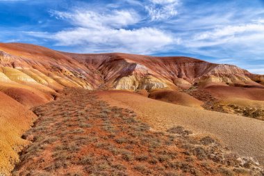 Kazakistan çölündeki Akzhar Ulytau tebeşir dağları. Çamur, kum, tebeşir ve çakıl gibi çok renkli katmanları olan nadir kumlu tepeler, seyrek bitki örtüsüyle medeniyetten çok uzakta.