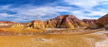 Kazakistan 'ın panoramik Akzhar Ulytau tebeşir dağları. Çamur, kum, tebeşir ve çakıl gibi çok renkli katmanları olan nadir kumlu tepeler, seyrek bitki örtüsüyle medeniyetten çok uzakta.