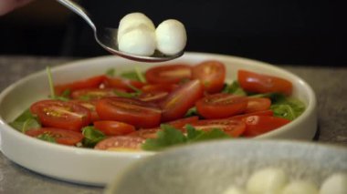 Mozzarella peynirli toplar ve kırmızı vişneli domates, Turning. Seçici odaklanma. Mini mozzarella soslu kanepeler, domatesler kiraz ve soya soslu fesleğen..