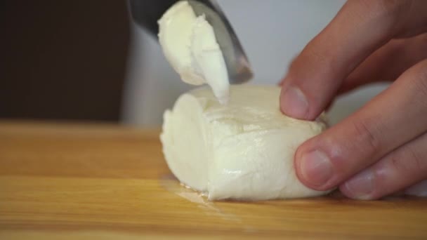 Bir Adam Ahşap Bir Tahtanın Üzerinde Bir Bıçakla Mozzarella Peyniri — Stok video