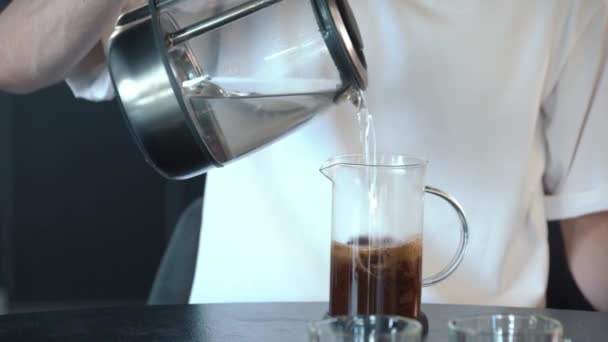 フランス製のプレスコーヒーを自宅のワーキングテーブルに置きます プランジャーを下に押す — ストック動画