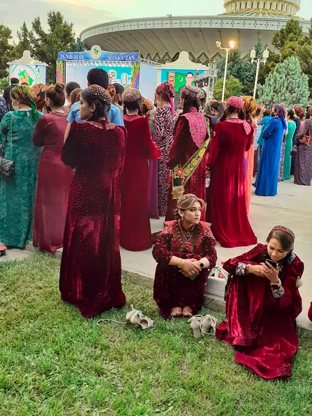 土库曼斯坦阿什哈巴德 2022年5月25日 两名身穿民族服装的身份不明的女孩正在看手机 — 图库照片