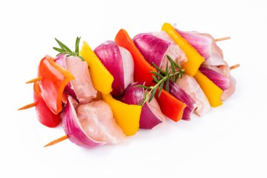 Uncooked mixed meat skewer with peppers.Skewers with pieces of raw meat, red, yellow and green pepper.Top view.Raw chicken skewers with vegetables, peppers, onions, on a white background.