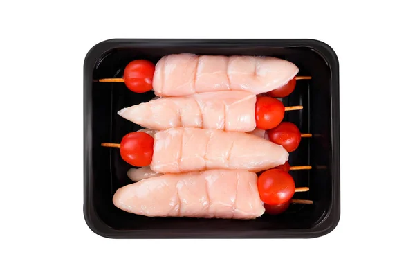 Raw chicken skewers.Raw chicken inner on skewers with tomatoes in a tray on a white background.Close-up.Top view.