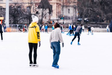 04.01.2022 Budapeşte. Çocuklar ve yetişkinler kış günü açık havada buz pateni pistine giderler. Aile kış sporu. Yumuşak, seçici odaklanma. Açık hava. Kış sporu..