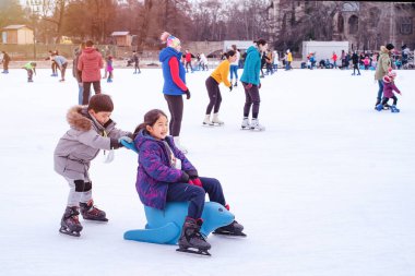 04.01.2022.Budapest.Family winter sport.Holiday and seasonal concept.Happy little boy and girl learning to skate in winter.Hobbies and Leisure.Winter sports.Activity,Adult,Child,Childhood, Daughter.