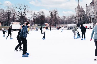 04.01.2022 Budapeşte. Mutlu küçük oğlan ve kız kışın paten kaymayı öğreniyor. Hobiler ve boş zaman. Kış sporları. Aile kışı sporu..