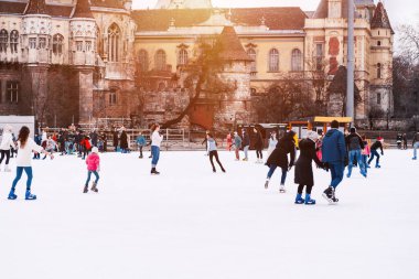 04.01.2022 Budapeşte. Çocuklar ve yetişkinler kış günü açık havada buz pateni pistine giderler. Aile kış sporu. Yumuşak, seçici odaklanma. Açık hava. Kış sporu..