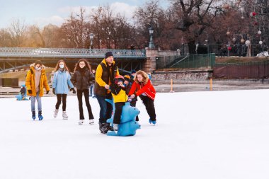 04.01.2022.Budapest.Winter sports.Family winter sport.Holiday and seasonal concept.Activity,Adult,Child,Childhood, Daughter.Happy little boy and girl learning to skate in winter.Hobbies and Leisure.