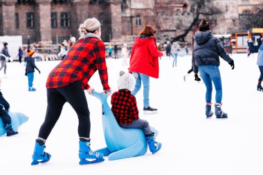 Winter sports.Family winter sport.Holiday and seasonal concept.Activity,Adult,Child,Childhood, Daughter.Happy little boy and girl learning to skate in winter.Hobbies and Leisure.