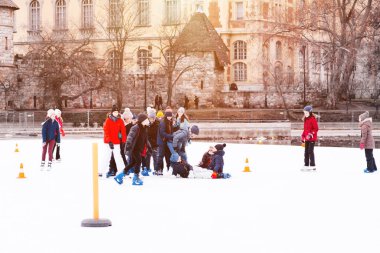 04.01.2022 Budapeşte. Çocuklar ve yetişkinler kış günü açık havada buz pateni pistine giderler. Aile kış sporu. Yumuşak, seçici odaklanma. Açık hava. Kış sporu..