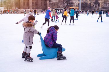 04.01.2022.Budapest.Winter sports.Family winter sport.Holiday and seasonal concept.Activity,Adult,Child,Childhood, Daughter.Happy little boy and girl learning to skate in winter.Hobbies and Leisure.
