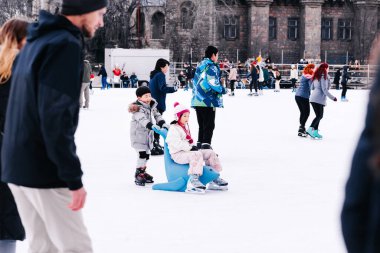 04.01.2022.Budapest.Happy little boy and girl learning to skate in winter.Hobbies and Leisure.Winter sports.Family winter sport.Holiday and seasonal concept.Activity,Adult,Child,Childhood, Daughter.