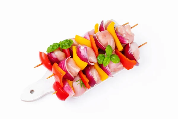 Chicken Skewers meat.Raw chicken leg meat skewers with vegetables,peppers, onions,white background.Uncooked mixed meat skewer with peppers.Skewers with pieces of raw meat, red, yellow pepper.Top view.