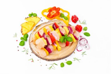 Skewers with pieces of raw meat, red, yellow pepper.Top view.Chicken Skewers breast fillet meat.Uncooked meat skewer.Raw pieces of chicken skewers with pepper onion and pineapple white background.