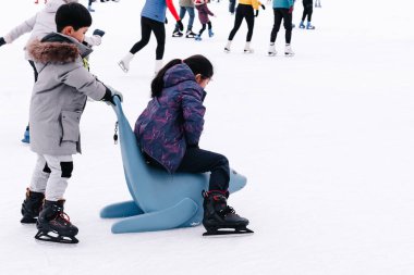 Happy little boy and girl learning to skate in winter.Hobbies and Leisure.Winter sports.Family winter sport.Holiday and seasonal concept.Activity,Adult,Child,Childhood, Daughter.