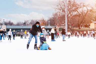 Family winter sport.Holiday and seasonal concept.Happy little boy and girl learning to skate in winter.Hobbies and Leisure.Winter sports.Activity,Adult,Child,Childhood, Daughter.