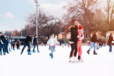 04.01.2022.Budapest.Family winter sport.Sports and fun pastime.Happy little boy and girl learning to skate in winter.People ride on the skating rink on the ice rink during the Christmas holidays.