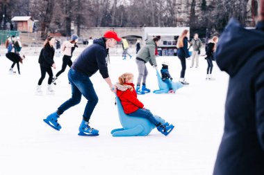 04.01.2022.Budapest.Winter sports.Family winter sport.Holiday and seasonal concept.Activity,Adult,Child,Childhood, Daughter.Happy little boy and girl learning to skate in winter.Hobbies and Leisure.