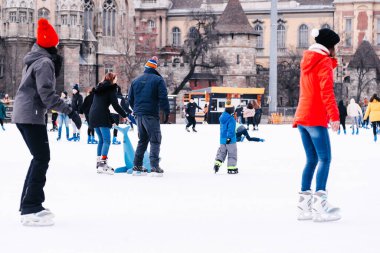 04.01.2022.Budapest.Winter sports.Family winter sport.Holiday and seasonal concept.Activity,Adult,Child,Childhood, Daughter.Happy little boy and girl learning to skate in winter.Hobbies and Leisure.